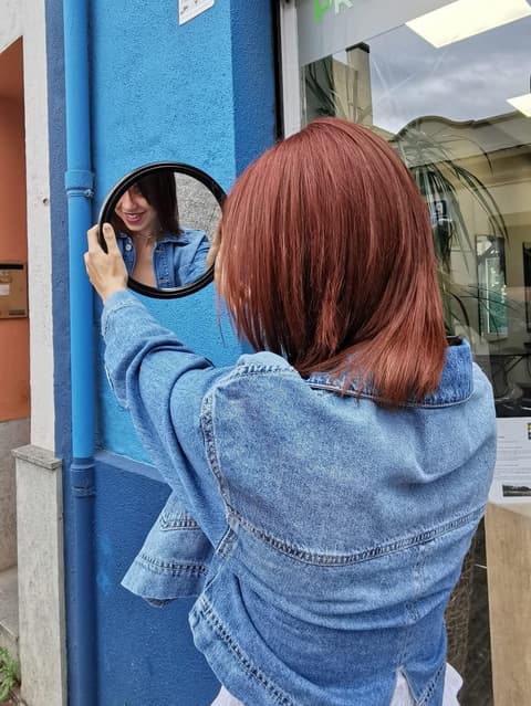 Noia mirant el tall en un mirall